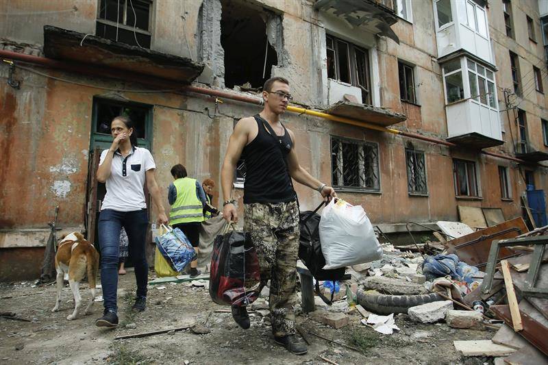 25/08/2016. Varias personas sacan escombros de una vivienda afectada por un bombardeo en Gorlovka, en el area de Donestsk, Ucrania. El presidente de Ucrania alerta sobre las intenciones de Putin (Foto: EFE)