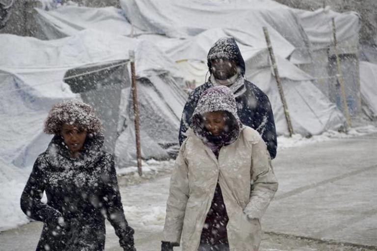 Varios refugiados caminan bajo la nieve en Moria, Lesbos. (Foto: EFE)