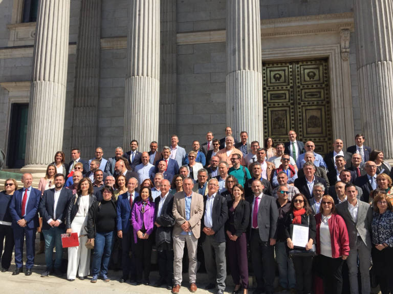 Foto de familia de los alcaldes y otros dirigentes en Madrid para protestar por la ausencia de inversión al transporte metropolitano
