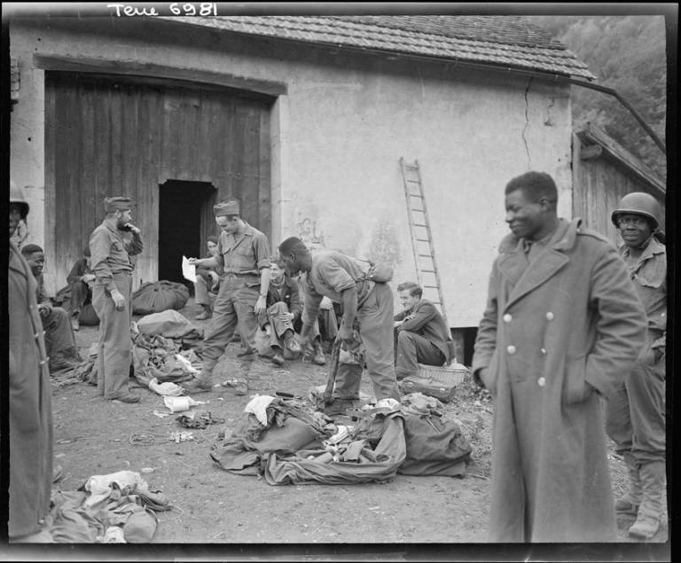 En Cornimont, resistents de les FFI (Forces Franceses de l'Interior), recentment integrats en les unitats regulars, intercanvien les seues robes civils pels uniformes del tirailleurs senegalesos als quals reemplacen,1944 © ECPAD.