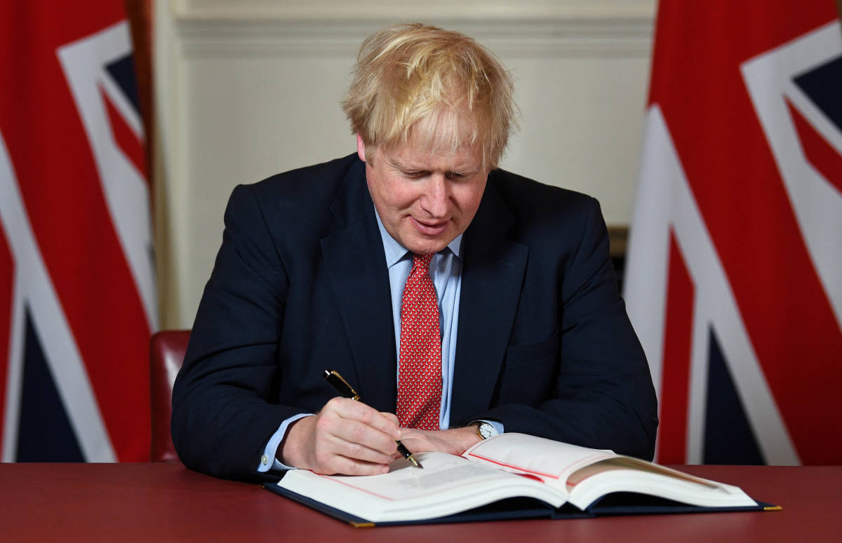 El primer ministro Boris Johnson firma el acuerdo de salida de la UE. Foto: ANDREW PARSONS