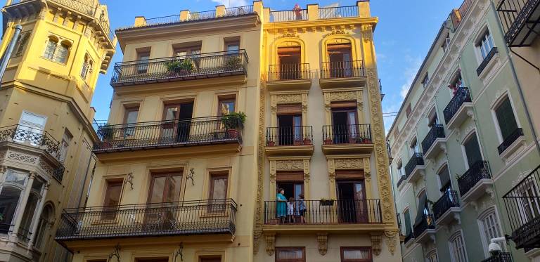 Vecinos asomados a los balcones en un edificio del centro histórico de València.
