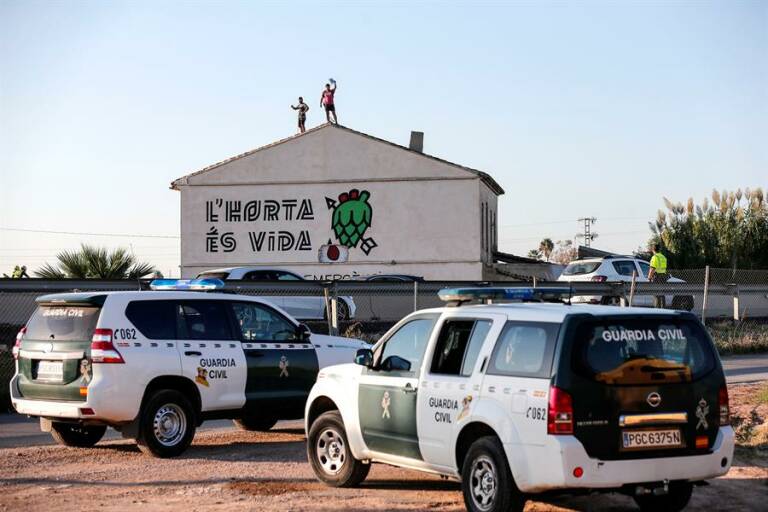 Dos activistas en el tejado del Forn de Barraca, durante la intervención policial para desalojarla. Foto: EFE