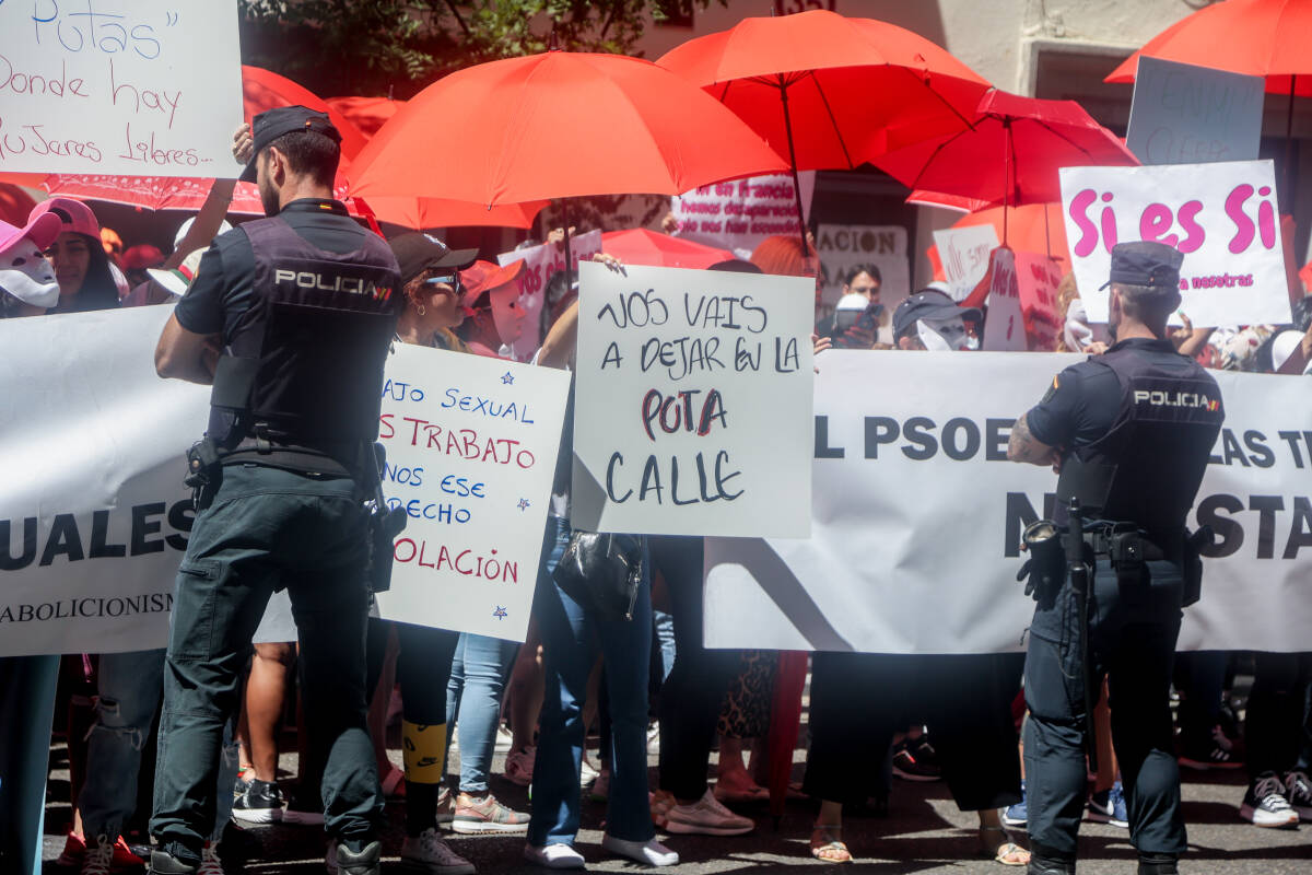 Varias personas con pancartas y paraguas rojos, frente a la policía, protestan durante una concentración, en la sede del PSOE en calle Ferraz, a 2 de junio de 2022, en Madrid (España). Foto: Ricardo Rubio / Europa Press