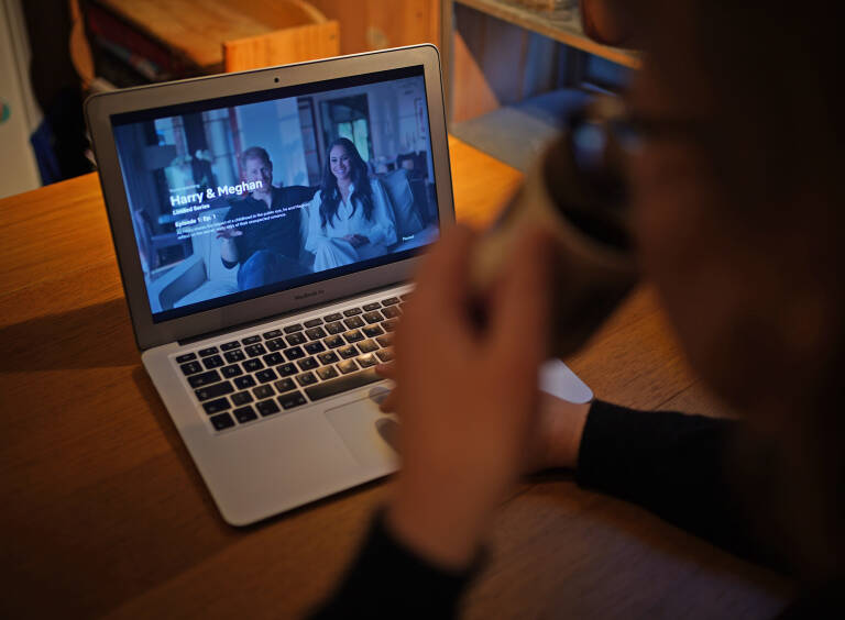 Una mujer viendo el documental de Harry y Meghan en Netflix. Foto: YUI MOK/PA WIRE/DPAU