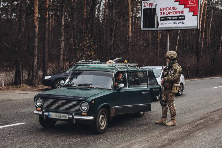 Un soldado del ejército ucraniano comprueba la documentación de un civil que huye de Irpin. Foto: DIEGO HERRERA/EP