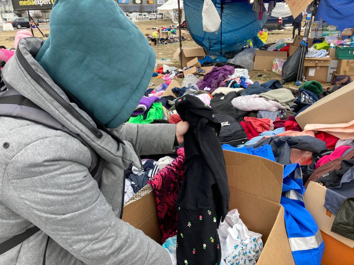 Una mujer busca ropa en el centro de refugiados. Foto: Jose Forés