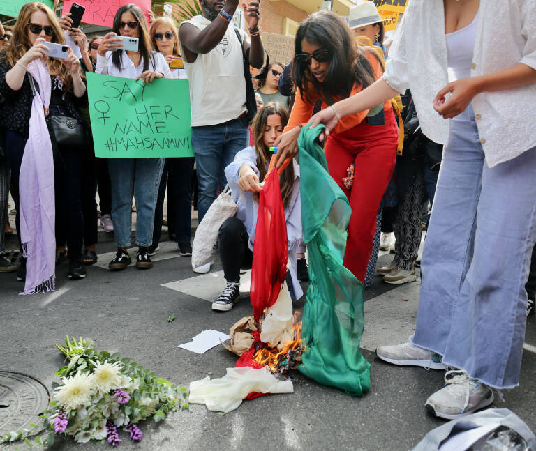 Varias mujeres queman velos islámicos frente a la embajada de Irán. Foto: CÉZARO DE LUCA/EP