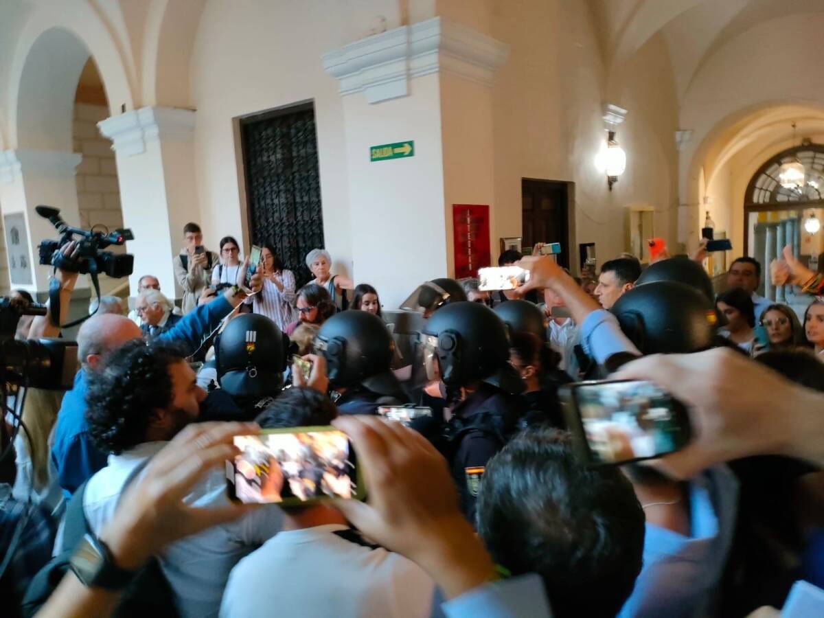 Detractores y simpatizantes de Macarena Olona, a su llegada a la Facultad de Derecho de Granada, rodeada de policías y periodistas. Foto: EP