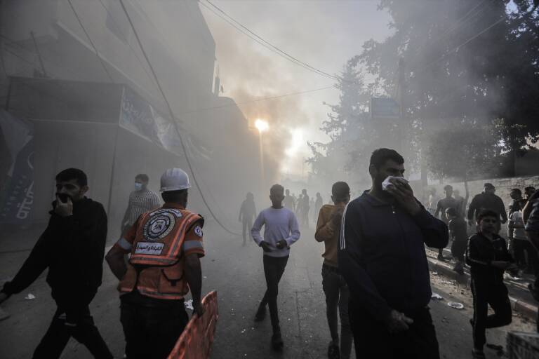 Palestinos caminan entre el humo tras un ataque aéreo israelí en Khan Yunis. Foto: MOHAMMED TALATENE/DPA