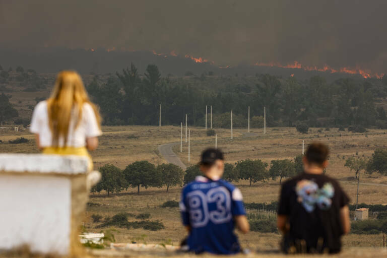 Varias personas observan las llamas del incendio en Bejís desde El Toro. Foto: ROBER SOLSONA/EP