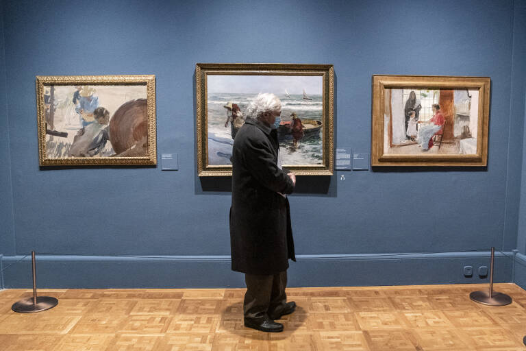 Un hombre delante de varias obras de Joaquín Sorolla en una exposición. Foto: A. PÉREZ MECA/EP