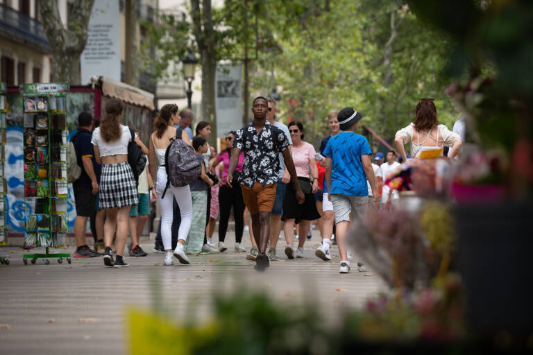 Varias personas caminan por las Ramblas, en Barcelona. Foto: DAVID ZORRAKINO/EP
