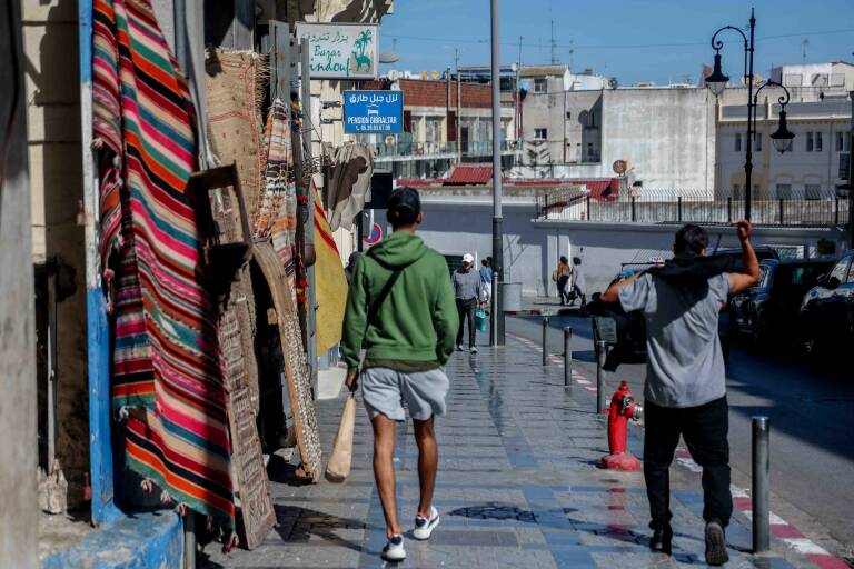 Varias personas caminan por una calle con tiendas en Tánger. Foto: RICARDO RUBIO/EP