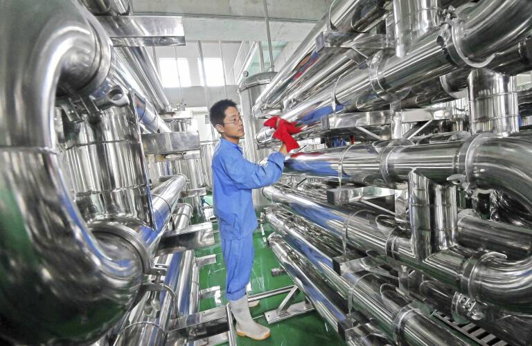 Un empleado limpia unos equipos en una fábrica de vinos en Weifang, China. Foto: CHINA DAILY CHINA DAILY INFORMATION CORP/CDIC